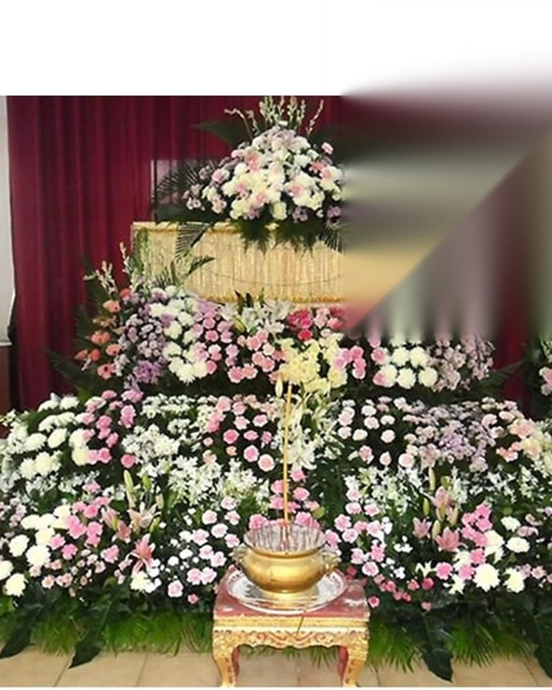 ดอกไม้จัดโทนขาวตั้งภายในศาลาบำเพ็ญกุศลของวัดในกรุงเทพฯ ก่อนเริ่มพิธี