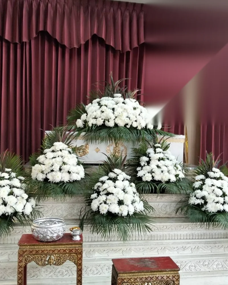 ดอกไม้หน้าศพ โทนขาวเขียว พุ่มขาวแซมกิ่งสน ส่งวัดในกรุงเทพ