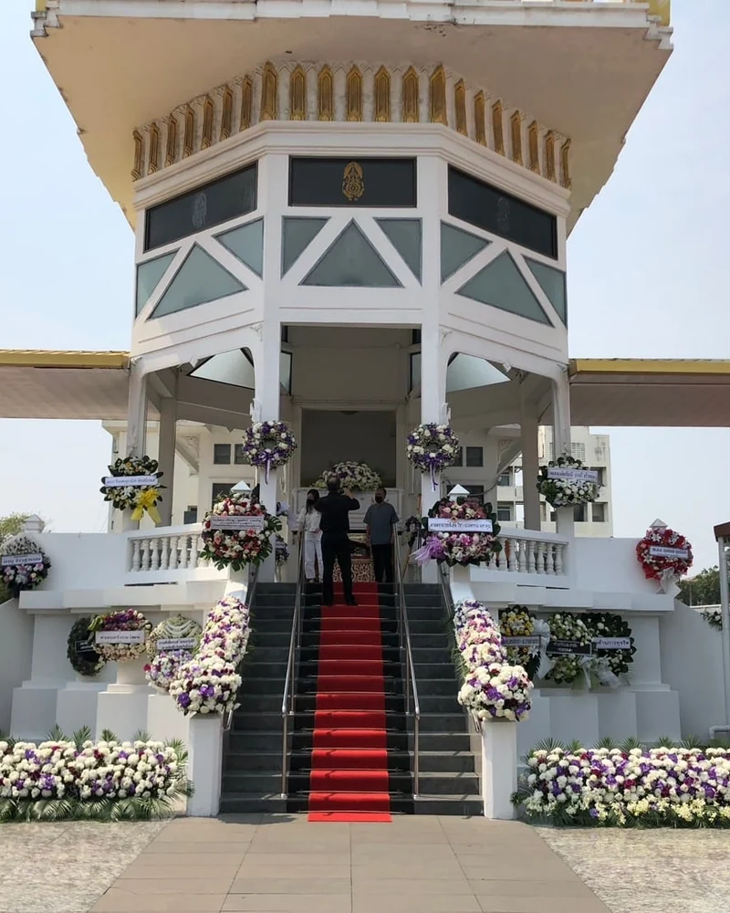 พวงหรีดตั้งเรียงสองข้างบันไดทางขึ้นศาลาของวัดในกรุงเทพฯ ในวันฌาปนกิจ